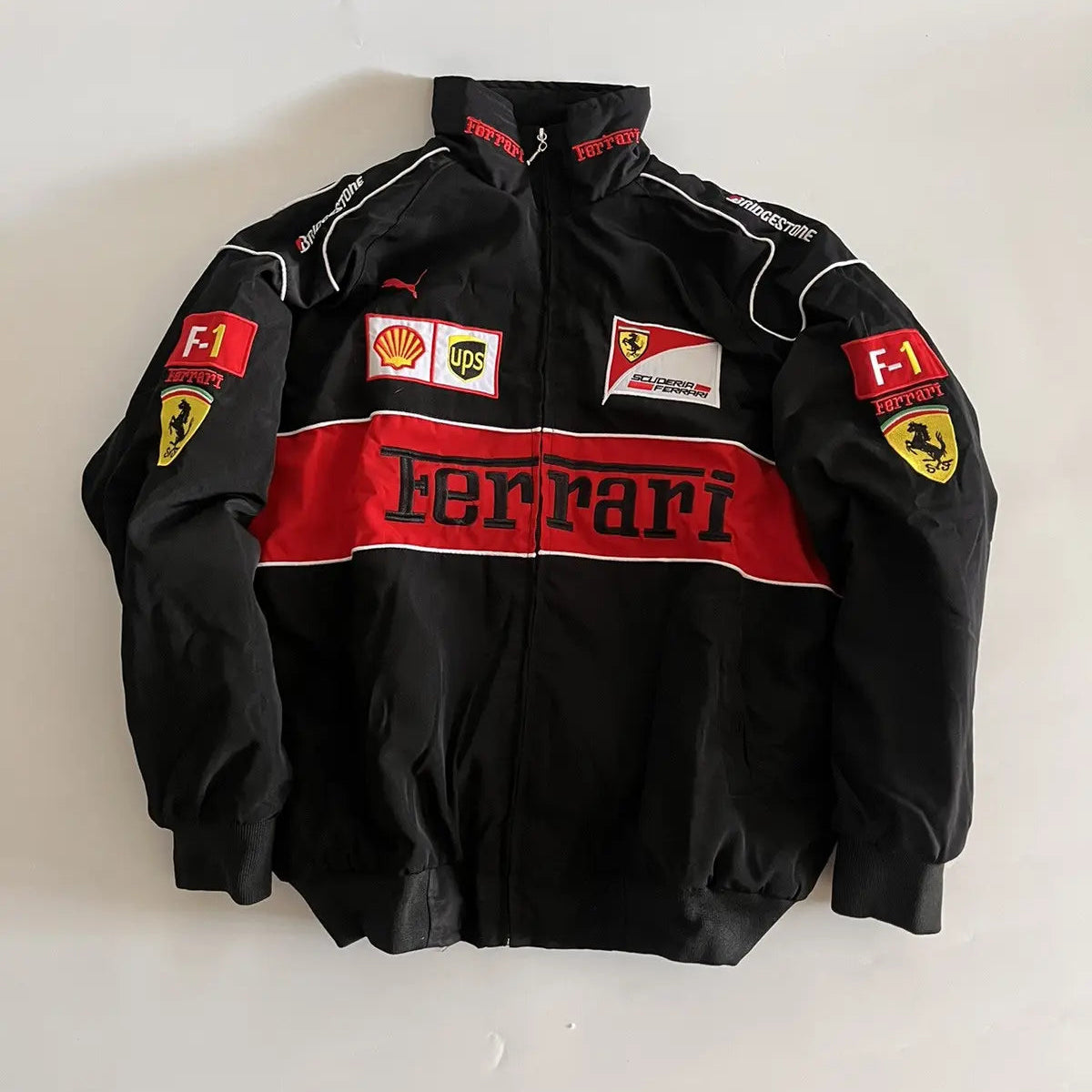 Black Ferrari jacket with logos on a white background